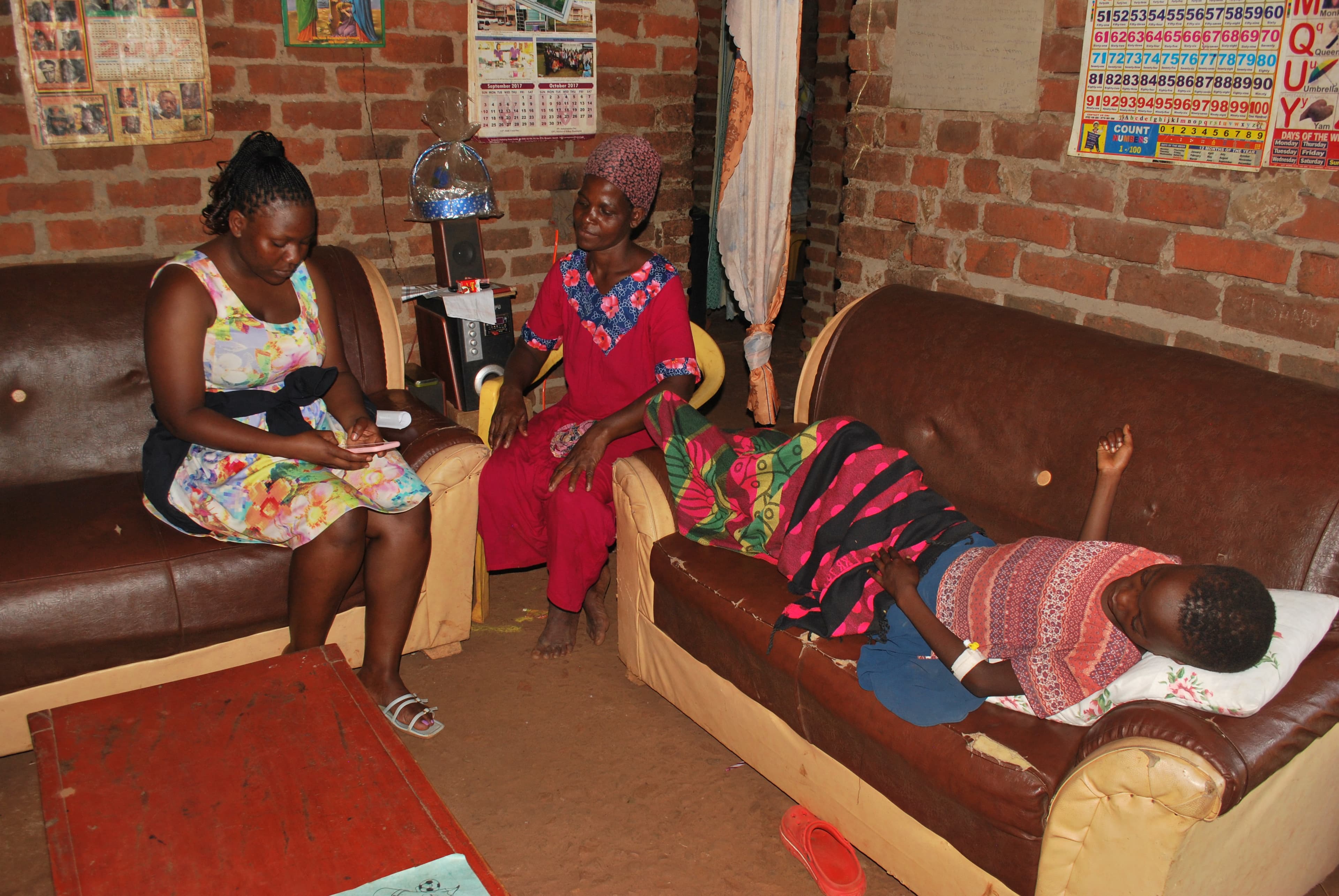 A girl rests at home through a sickle cell pain crisis while a community navigator visits her family.
