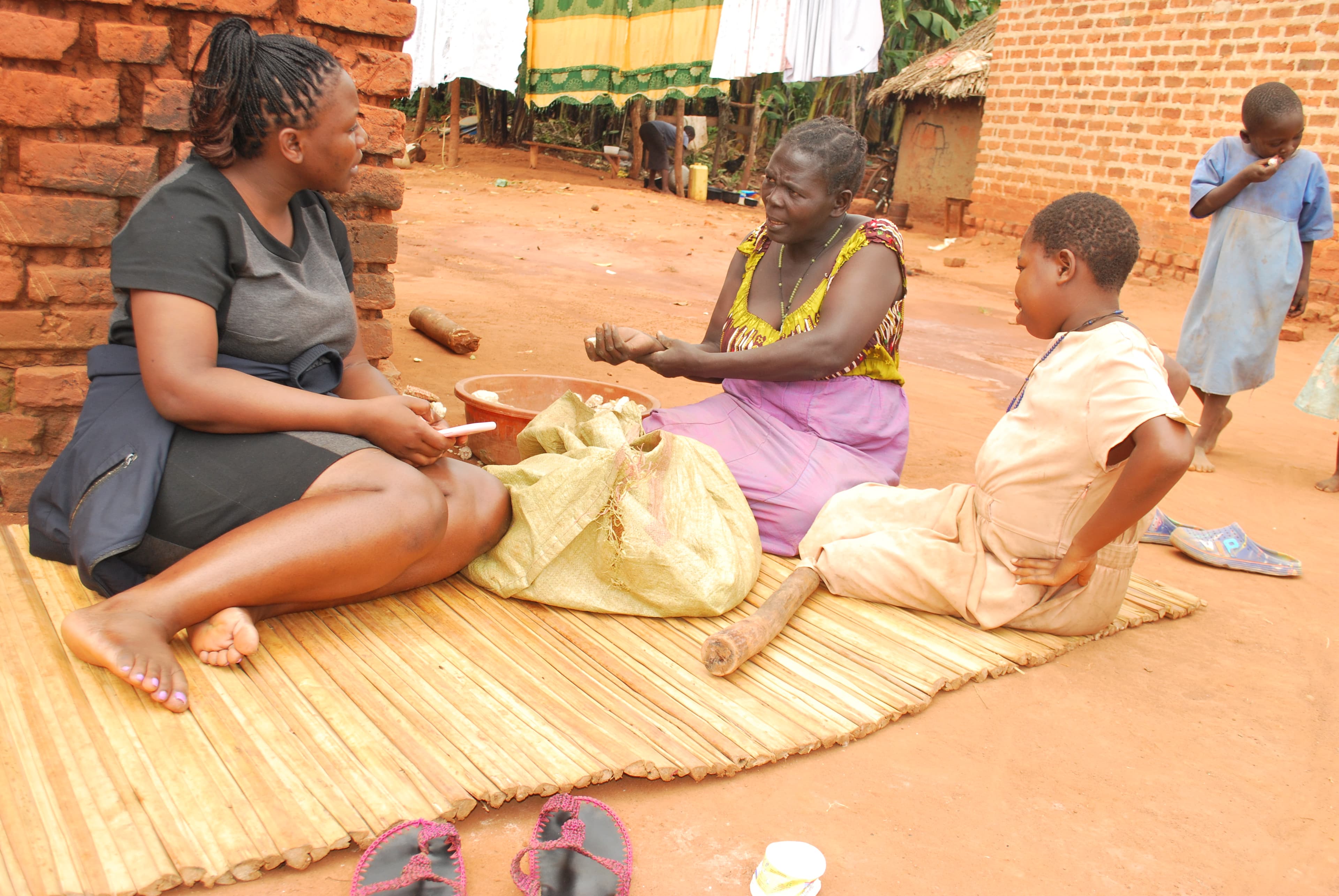 A community navigator sits with a family during a home visit, talking through a child's sickle cell care.