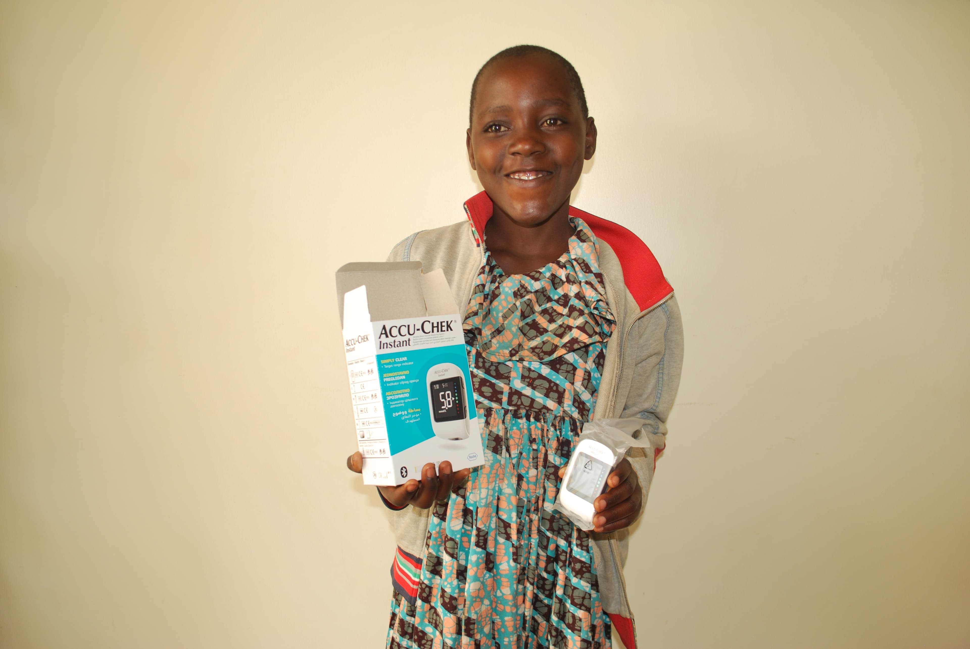 A girl living with type 1 diabetes holds her own glucose meter — the difference between guessing and knowing.